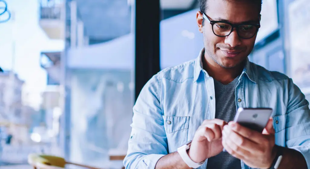 Male looking and smiling at smart phone