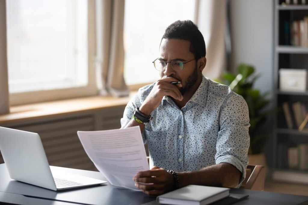 Man sitting at a desk looking at paperwork.