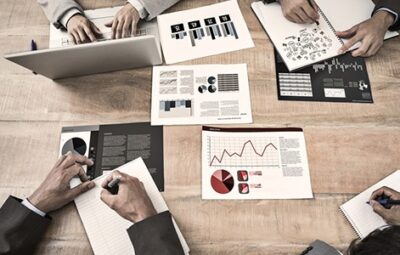 Men meeting around a table with graphs and data