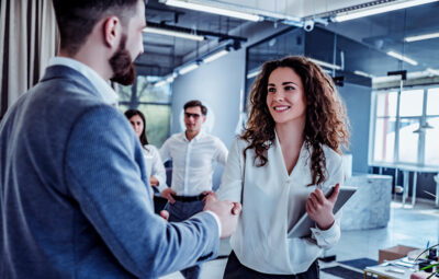 Woman shaking hands with a man in an office setting