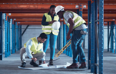 Construction workers reviewing blueprint plans at a job site