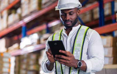 Man in a distribution center looking at smart phone