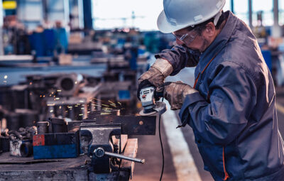 Man grinding metal in a manufacturing facility