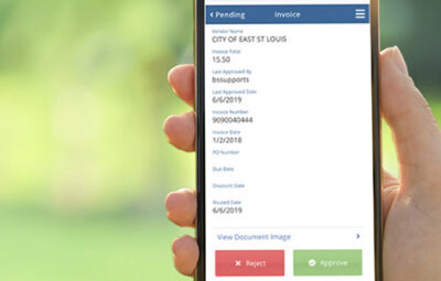 Woman's hand holding a smart phone with pending invoice information on the screen