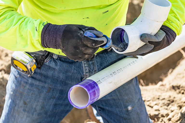 a plumber installing PVC pipe