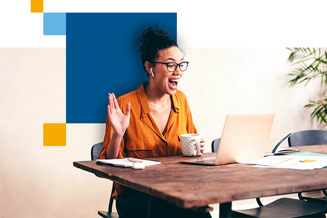 woman smiling and waving at computer screen during a virtual meeting