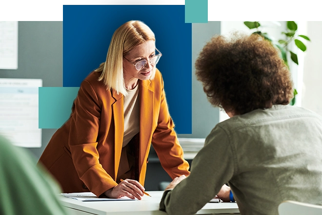 two women looking at a meeting and reviewing paperwork together